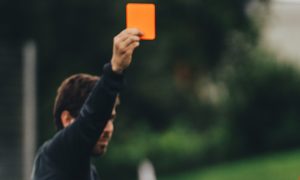 Referee brandishing a red card